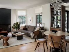 a living room filled with furniture and a fire place next to a dining room table