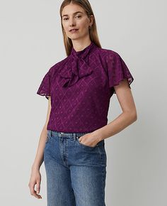 Elevate your wardrobe with the Ann Taylor Mock Neck Bow Top, a blend of elegance and comfort. This top features a sophisticated mock neck with charming bow ties and delicate shirring details below, creating a beautifully feminine silhouette.

- Size: XS (Regular)
- Color: Pulsar Purple
- Material: 100% Polyester
- Gender: Female
- Sleeve Length: Short
- Body Lining: Yes
- Length: 23 1/2 inches long
- Care Instructions: Machine Washable

Perfect for both office and casual wear, this blouse is des Women Work Blouse, Mock Neck Short Sleeve, Knitted Suit, Bow Top, Neck Bow, Blouse Tops, Mock Neck Top, Puff Sleeve Top, Work Blouse