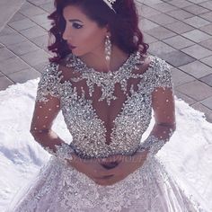 a woman in a wedding dress is looking down at her stomach and wearing a tiara