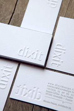 four business cards with the word dixie printed on them sitting on top of a wooden table