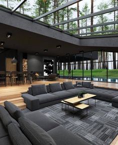 a living room filled with furniture next to a large glass wall covered in lots of windows