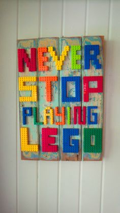 some type of art made out of legos on a wall with the words never stop playing