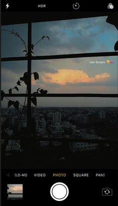 the sun is setting over a city with tall buildings in the foreground and clouds in the background