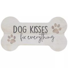 a wooden sign that says dog kisses for everything with paw prints on the front and back