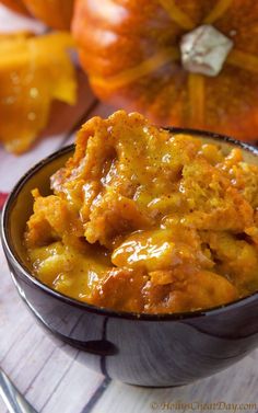 a close up of a bowl of food on a table with pumpkins in the background