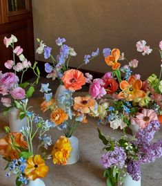 several vases filled with different types of flowers