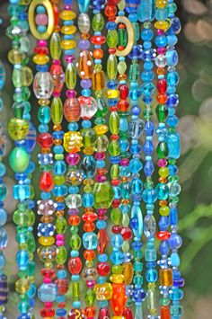 colorful beads hanging from the side of a tree