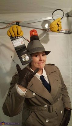 a woman dressed as a police officer with gloves on her head, holding a radio and looking at the camera