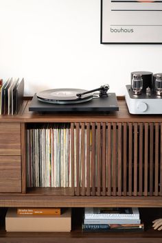 a record player sitting on top of a wooden shelf