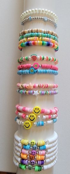 a stack of bracelets with smiley faces and beads on them, hanging from a wall