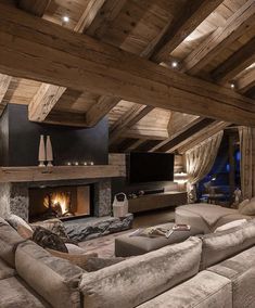 a living room with couches and a fire place in the middle of the room