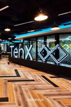 the inside of an office building with wood flooring and neon signs on the wall