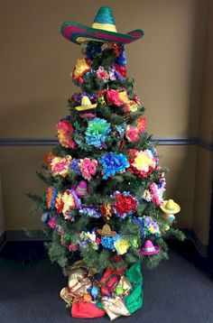 a small christmas tree decorated with colorful flowers and sombrero on it's top