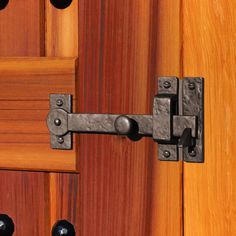 a close up of a wooden door with metal latches and knobs on it