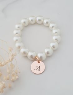 This sweet little pearl bracelet is personalised pearl to suit your bridal party. This bridal bracelet is made from 8mm glass pearls and 12mm rose gold plated initial disc. Your jewellery will arrive in a gift box ready for giving. This item ships from the UK within 1 working day. Please see size guide below: Sizes for children 3-6 months    4.25-4.5in 6-12 months    4.75in 12-24 months    5in 2-3 years    5.0-5.5in 4-5 years    5.75in 6-8 years    6in 9-13 years    6.25in Adult Sizes Small                  6.5in Medium             7in Large                  7.5in Elegant Hypoallergenic Name Bracelet With Round Beads, Pearl White Bracelet With Round Beads For Gifts, Pearl Charm Bracelet With Round Beads As Gift, Elegant Personalized Rose Gold Beaded Bracelets, Elegant Personalized Rose Gold Beaded Bracelet, White Pearl Drop Bracelets For Bridesmaids, White Pearl Drop Bracelet For Bridesmaids, Personalized Pearl Bracelet For Birthday, Elegant Charm Bracelet With Letter Beads