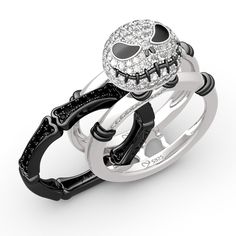 two wedding rings with skulls on them and diamonds in the middle, all set together