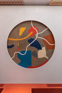 a circular artwork hanging on the side of a wall