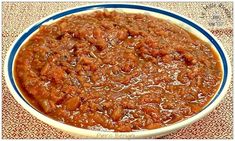 a bowl filled with chili and meat on top of a table