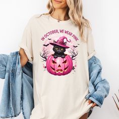 Celebrate Halloween and breast cancer awareness with this cute black cat witch shirt! Featuring a playful black cat sitting on a pink pumpkin with a witch hat, this shirt is perfect for October when we wear pink. Whether you're dressing up for spooky season or showing your support for breast cancer survivors, this tee is both fun and meaningful. Ideal for Halloween lovers who want to make a statement while spreading awareness. Available in multiple sizes, this design makes a great gift for anyon October Witch, Black Cat Witch, Halloween Pink, Pink Pumpkin, Halloween Lovers, Pink October, Pink Pumpkins, Cute Black Cats, Pumpkin Shirt