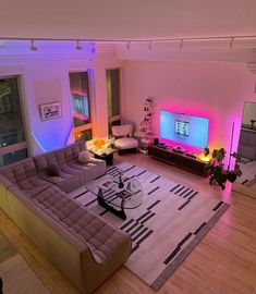 a living room filled with furniture and a flat screen tv sitting on top of a wooden floor