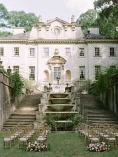 an outdoor ceremony setup in front of a large white building with steps leading up to it