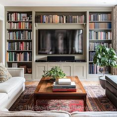 a living room filled with furniture and a flat screen tv mounted on a wall above a wooden coffee table