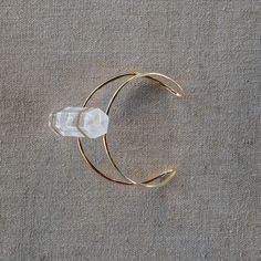 At the center of the gold-plated Wire Cuff Bracelet sits a single white crystal that is 2.5 inches in height. This striking arm band easily adjusts to the desired fit. The piece is simply stunning. SPECIFICATIONS:Approx. ½” x ½” x 2½” White Quartz Bendable cuff approx. 2½” dia This item is final sale and not eligible for return. Gold Adjustable Crystal Bangle Bracelet, Adjustable Gold Crystal Bangle Bracelet, White Adjustable Cuff Jewelry, White Crystal Bracelet, Wire Cuff Bracelet, Wire Cuff, Spring City, White Quartz, White Crystal