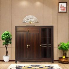 a wooden cabinet sitting next to a potted plant on top of a rug in front of a wall