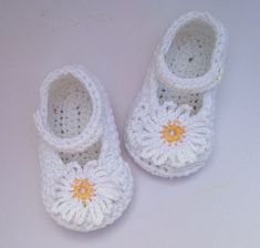 "These pretty crochet daisy shoes are perfect for spring and summer. They are made out of a lovely soft 100% cotton yarn,ideal for babies sensitive skin. The shoes are white with a white crochet daisy with yellow centre securely sewn onto the front of the shoe. A white button fastens the strap at the top of the shoe and helps to keep the shoe in place as well as give additional embellishment. The shoes are available in the following sizes newborn           3\" sole 0-3 months       3.25 \" sole Spring White Booties As Gift, Handmade White Closed Toe Booties, Cute White Spring Booties, Cute White Summer Booties, White Crochet Round Toe Booties, White Crochet Booties With Round Toe, Daisy Shoes, Shoes Mary Janes, Baby Daisy