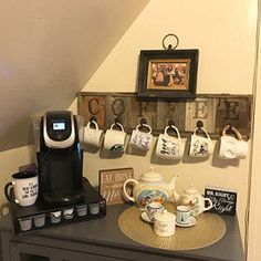 there is a coffee maker and cups on the counter in this room with other items