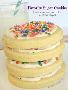 a stack of cookies with white frosting and sprinkles