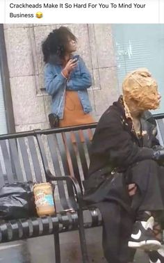 a woman sitting on a bench next to a man with a mask covering his face