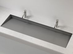 a bathroom sink with two faucets mounted on the wall next to each other