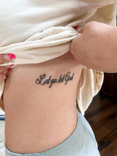 a woman with a tattoo on her stomach saying let go tell you