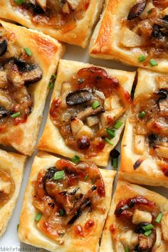 many square pieces of pizza with mushrooms on them