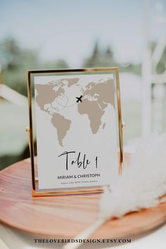 a wooden table topped with a sign and a white feather