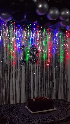 a birthday cake on a table in front of balloons and streamers with the number twenty eight