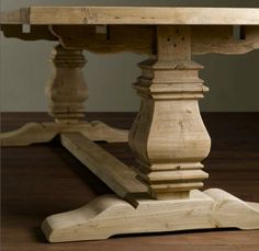 an old wooden table with some wood posts on the top and bottom, sitting on a hard wood floor