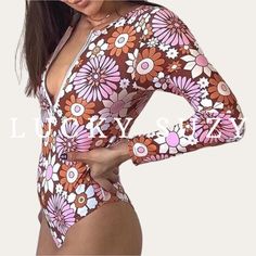 "1970s vintage Flower Power print long sleeve surf women swimsuit. Our charming rash guard one-piece features a high neckline with front zip, soft padding cups, and a cheeky bottom for a \"far out\" surfing babe look. 1970s Floral Print Trendy and flattering vintage style Easy-up front zipper with soft cup pads Covered back with a medium leg and cheeky bottom Imported FIT Fits true to size. To order the best size for you, use the chart provided. Please measure yourself and match your measurement Long Sleeve Floral Print Stretch Swimwear, Long Sleeve Floral Print Swimwear For Surfing, White Long Sleeve Bodysuit For Poolside, Spring Floral Print Long Sleeve Bodysuit, Spring Long Sleeve Floral Print Bodysuit, White Long Sleeve Bodysuit For Vacation, Fitted Long Sleeve Bodysuit With Floral Print, Multicolor Long Sleeve Swimwear For Poolside, Retro One-piece Bodysuit For Beach Season