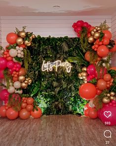 an image of a party with balloons and greenery on the wall in front of it