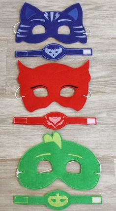 three masks with different colors and designs on them, one is red, one is green