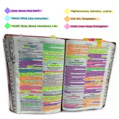 an open bible with colorful text on it