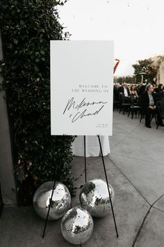 a sign that is sitting on top of some metal balls in front of a building