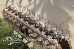 an overhead view of a long table set with plates and silverware for a formal dinner