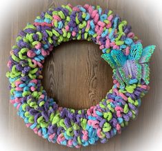 a colorful yarn wreath with a butterfly on it