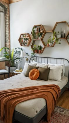 a bed with an orange blanket on top of it and some shelves above the headboard