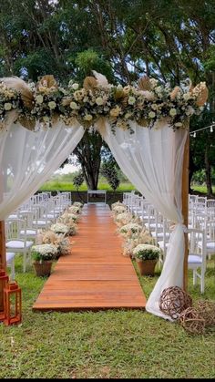 an outdoor ceremony setup with white drapes and flowers