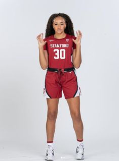 a young woman is posing for a photo wearing shorts and a shirt with the number 30 on it