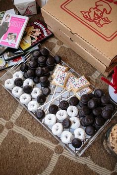 an assortment of doughnuts and pastries are on the floor next to a box of donuts