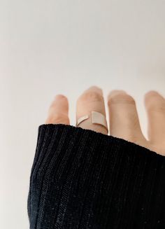 Crafted for elegance and simplicity, this Sleek Sterling Silver Open Band Ring showcases a Contemporary Matte Finish, embodying adjustable minimalism at its finest.  The open band design provides a custom fit for any wearer, while its sterling silver composition ensures lasting shine and durability.  Perfect for those who appreciate modern, understated jewelry, this ring comes in a branded organic cotton pouch, ideal for gifting or as a timeless addition to your collection. To find your size, me Modern Adjustable Rings For Everyday, Adjustable Modern Midi Rings, Adjustable Modern Stackable Rings, Modern Adjustable Stackable Rings, Modern Adjustable Open Ring, Minimalist Adjustable Metal Ring Jewelry, Simple Open Band Jewelry For Everyday, Simple Adjustable Rose Gold Midi Rings, Adjustable Simple Rose Gold Midi Rings